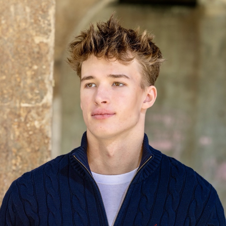 John Jacobson, head and shoulders, outdoors in a navy quarter-zip sweater.